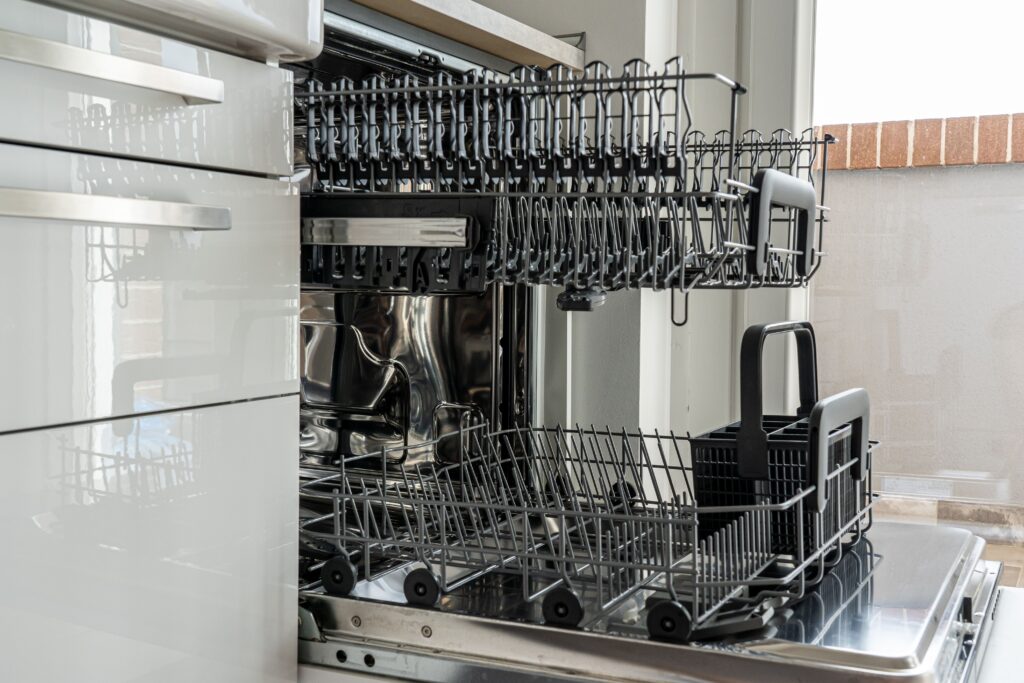 Open and empty dishwasher in a sunlit modern kitchen ready for use,